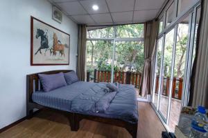 a bed in a room with a large window at อินทนนท์ขุนเล่าลือ in Ban Na Yang