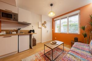 a kitchen and a living room with a couch and a table at Air Nomad • Marrakech in Valenciennes +9 photos