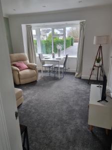 a living room with a table and a couch at Plum Cottage in Keswick