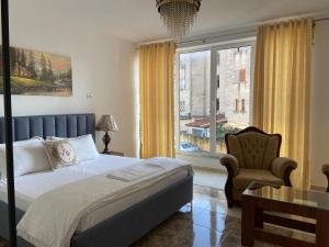 a bedroom with a bed and a chair and a window at North Star Hotel in Shkodër