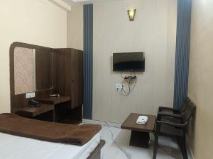 a room with a bed and a table and a mirror at hotel atithi palace in Jabalpur