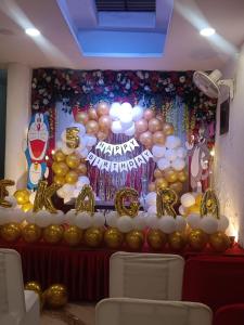 a room with a wall filled with gold and balloons at hotel atithi palace in Jabalpur