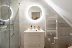 a bathroom with a sink and a shower with a mirror at Air Nomad • Bali in Valenciennes