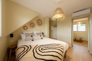 a bedroom with a large bed and a chandelier at Air Nomad • Bali in Valenciennes