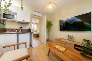 a living room with a large tv on the wall at Air Nomad • Bali in Valenciennes