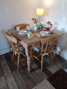 a wooden table with plates and cups on it at Middlehope Cottage in Westgate