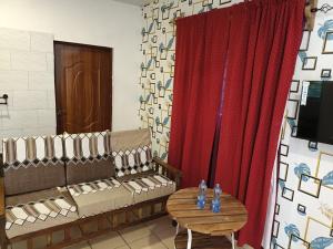 a room with a couch and a table and a red curtain at Escape Retreats in Diani Beach