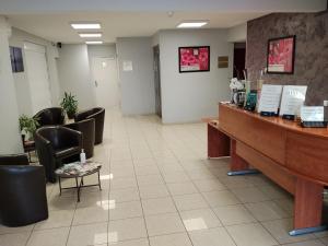 a waiting room with chairs and a reception desk at Contact Hôtel - Prim Witry - Reims Nord in Reims
