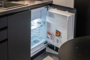 an empty refrigerator with its door open in a kitchen at Luxury Resort Orava in Orava