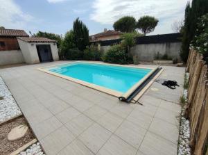 a swimming pool in a backyard with a tiled patio at Quiet house, sun and pool in Le Thor