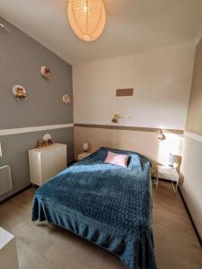 a bedroom with a bed with a blue blanket at Quiet house, sun and pool in Le Thor