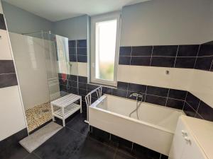 a bathroom with a bath tub and a window at Quiet house, sun and pool in Le Thor +16 photos
