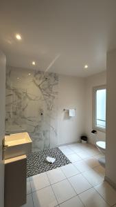a bathroom with a shower and a sink and a toilet at Hotel Richmond Gare du Nord in Paris