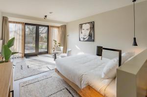 a bedroom with a bed and a large window at Van Heeckeren City Centre Jacuzzi Lofts in Nes