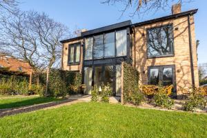 a house with large windows and a lawn at Van Heeckeren City Centre Jacuzzi Lofts in Nes