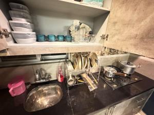 a kitchen with a sink and a counter top with dishes at Moonlit Cinema Suite in Lahore +3 photos