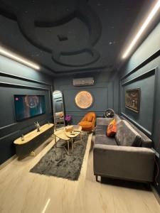 a living room with a couch and a table at Moonlit Cinema Suite in Lahore