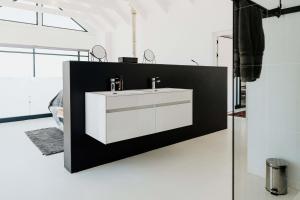 a bathroom with a white sink on a wall at Beyond The Beach in Yzerfontein +67 photos
