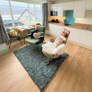 a living room with two chairs and a rug at Sunray Suites in Barmouth +15 photos