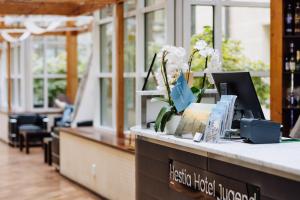 a lobby with a counter with flowers on it at Hestia Hotel Jugend in Riga