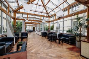 an empty lobby with black furniture and windows at Hestia Hotel Jugend in Riga