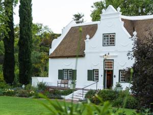 a white house with green shutters at Navarre Residence in Stellenbosch