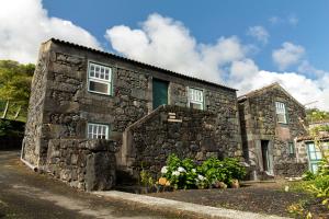 a stone house with a stone wall at Adegas do Pico in São Roque do Pico +58 photos