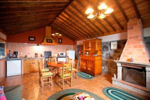 a kitchen and dining room with a table and a fireplace at Adegas do Pico in São Roque do Pico