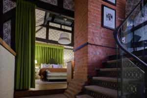 a staircase leading to a bedroom with a green curtain at Hotel du Vin Henley in Henley on Thames