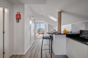 a kitchen with white walls and a counter with stools at Brito's Guest House - Monthly Rentals & Digital Nomads in Funchal