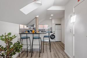 a kitchen with a counter and stools in a room at Brito's Guest House - Monthly Rentals & Digital Nomads in Funchal