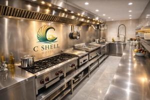 una grande cucina con elettrodomestici in acciaio inossidabile di C Shell Hotel a Jounieh