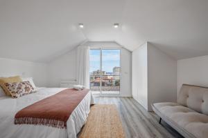 a white bedroom with a large bed and a couch at Brito's Guest House - Monthly Rentals & Digital Nomads in Funchal