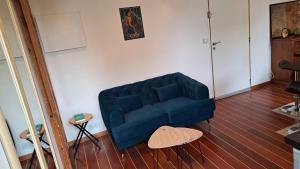 a blue couch sitting in a living room at Studio à 70m des flots in Trébeurden +1 photo