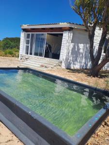 a pool of water in front of a house at Lumberjack Cottage at Blombosch Game Farm in Yzerfontein