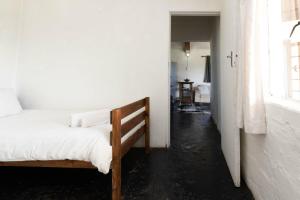 a bedroom with a bed in a white room at Lumberjack Cottage at Blombosch Game Farm in Yzerfontein