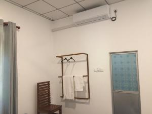 a bathroom with a mirror and a towel rack at Mimi's Cottage in Udawalawe