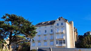a white building with a sign on it at Studio à 70m des flots in Trébeurden
