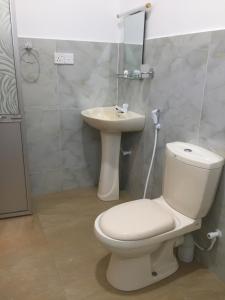 a bathroom with a toilet and a sink at Mimi's Cottage in Udawalawe