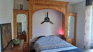 a bedroom with a wooden bed with a ceiling fan at Studio à 70m des flots in Trébeurden