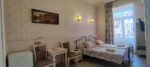 a bedroom with a bed and a table and chair at Hidden Rooms Freedom Square in Tbilisi City