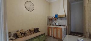 a living room with a couch and a clock on the wall at Hidden Rooms Freedom Square in Tbilisi City