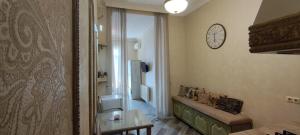 a living room with a clock on the wall at Hidden Rooms Freedom Square in Tbilisi City +39 photos