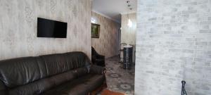 a living room with a couch and a tv on a wall at Hidden Rooms Freedom Square in Tbilisi City
