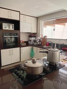 a kitchen with two pots and pans on a stove at Casa Compartilhada na CBF, granja comary in Teresópolis
