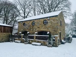 a stone building with snow on top of it at Pingle Nook Barn on the Farm - Denby Dale in Huddersfield