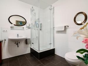 a bathroom with a shower and a sink and a toilet at Beim Thöny - schönes Apartment mit privatem Zugang in Utting am Ammersee
