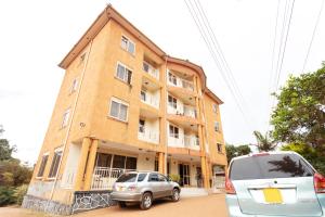 two cars parked in front of a building at Admiral Hotel and Spa Kampala in Kampala
