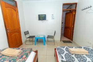a room with two beds and a table and a tv at Admiral Hotel and Spa Kampala in Kampala