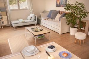 a living room with a couch and a table at Villa Pierre Blanche le calme a 5mn du centre ville in Nîmes